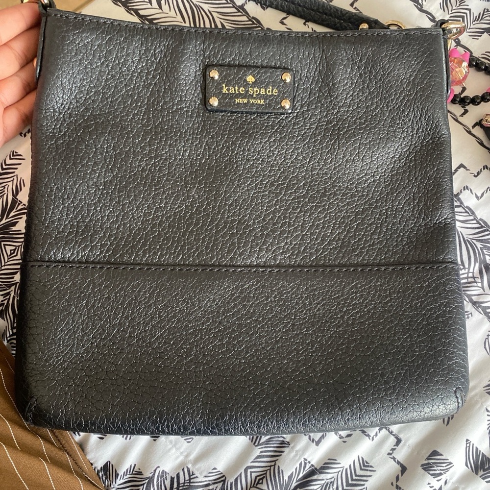 Black Kate spade New York leather bag with polkadots in the inside.